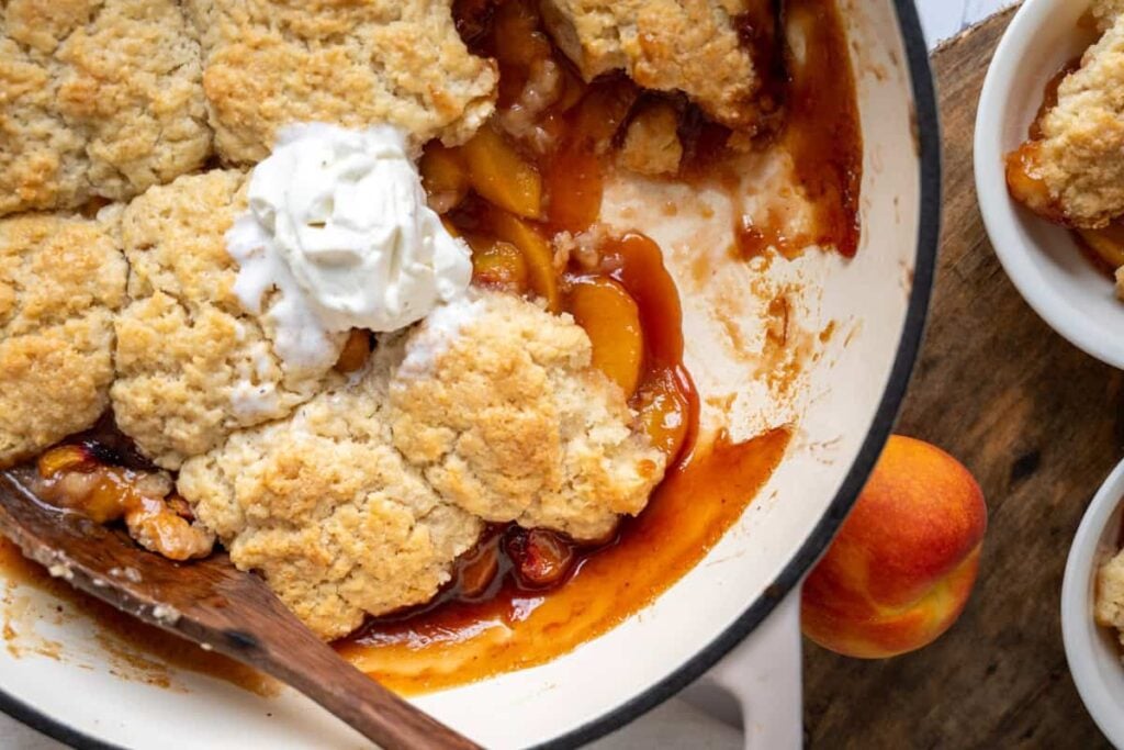 sourdough peach cobbler in a braiser