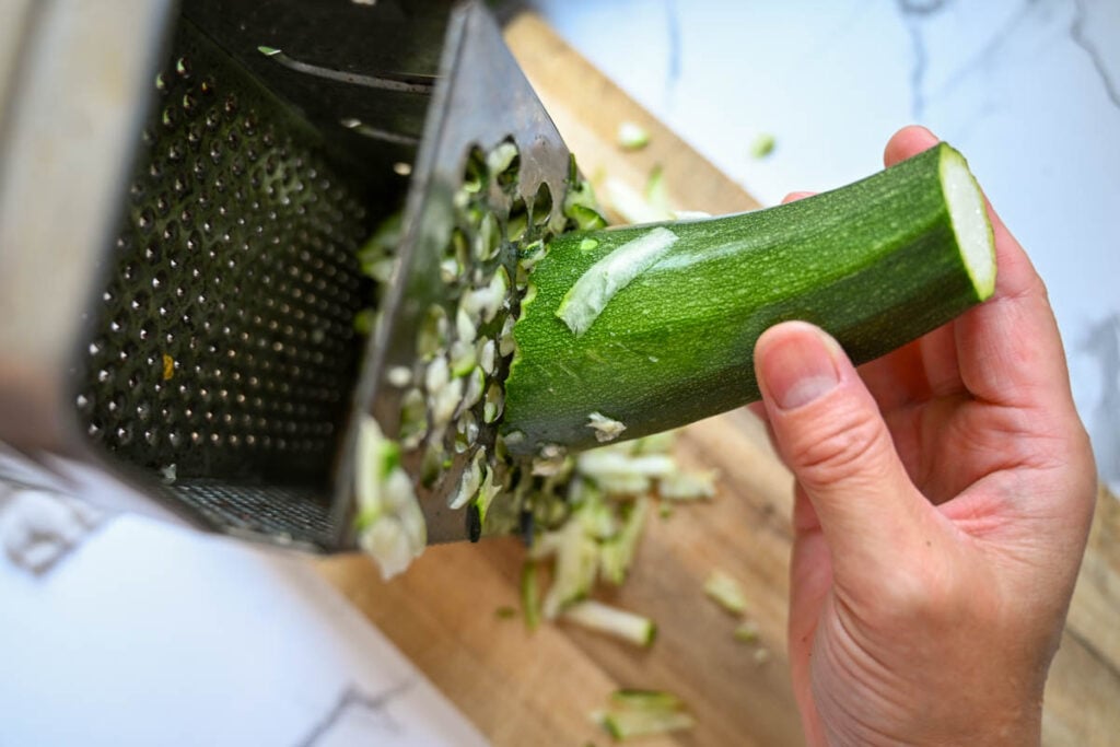 grating zucchini on a box grater
