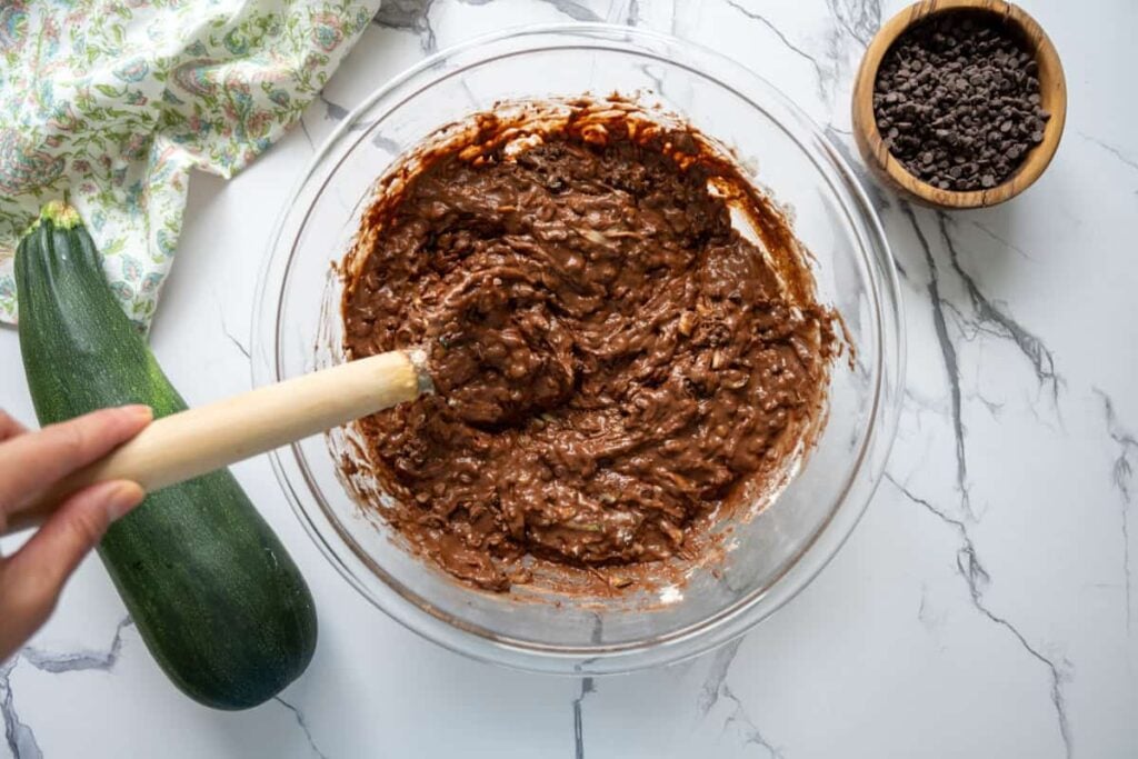 the ingredients for chocolate sourdough zucchini cake in a glass bowl