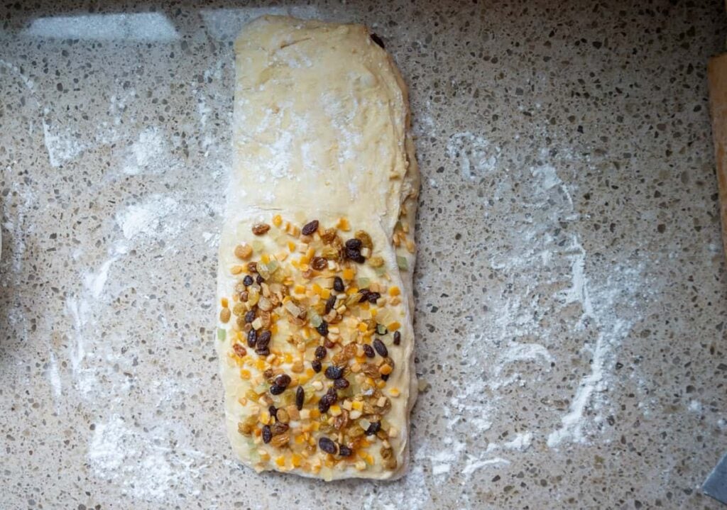adding dried fruit to folded sourdough panettone dough