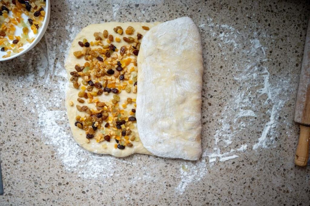 folding sourdough panettone bread dough studded with dried fruit