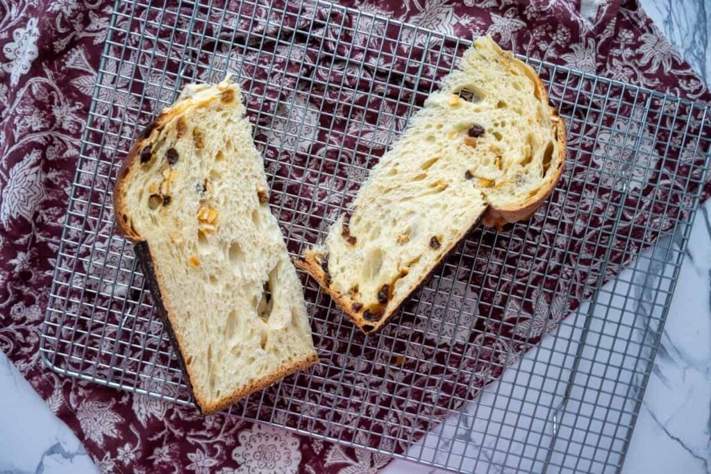 slices of sourdough panettone bread on a wire rack over a red cloth