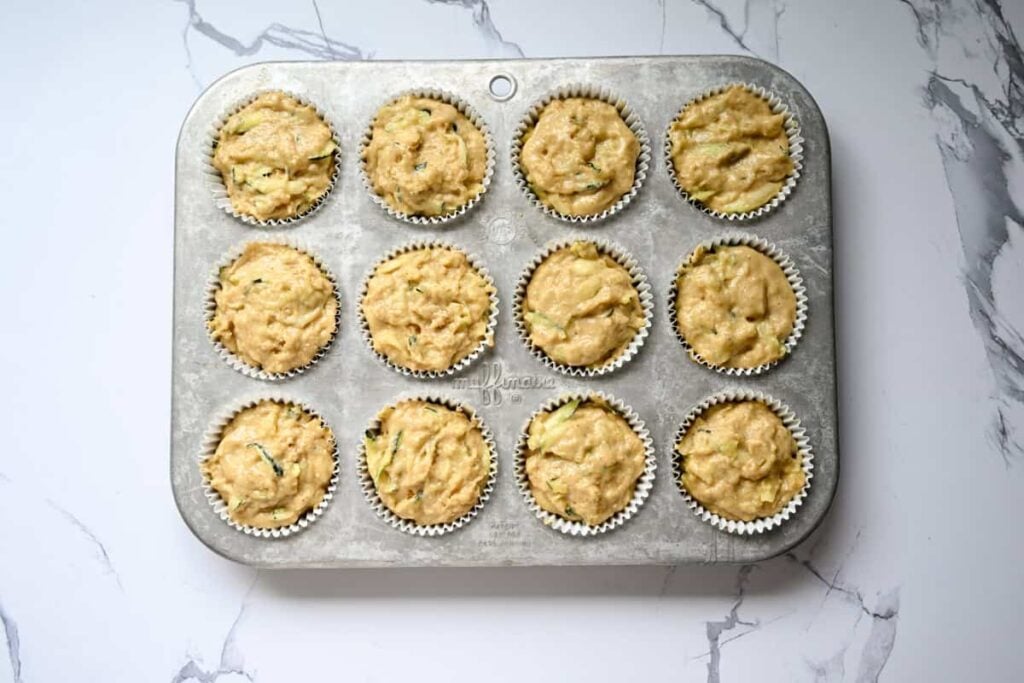 sourdough zucchini batter in a muffin pan