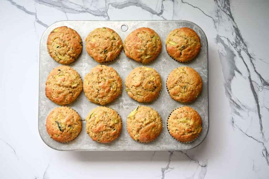 baked sourdough zucchini muffins in a muffin pan