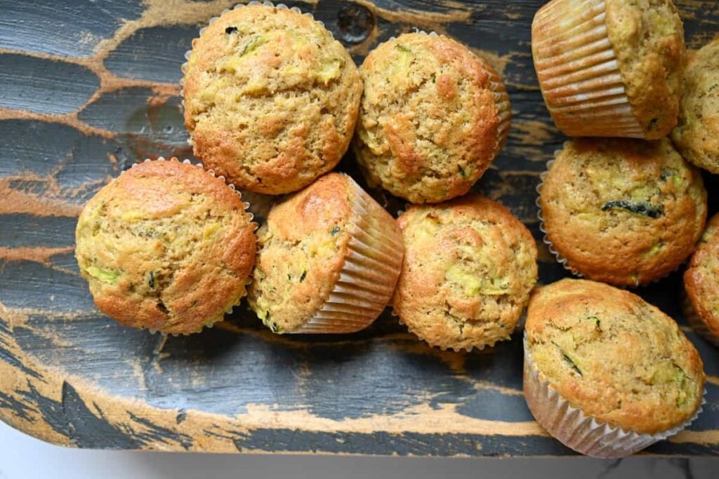 a stack of one bowl sourdough zucchini muffins in a wooden bowl