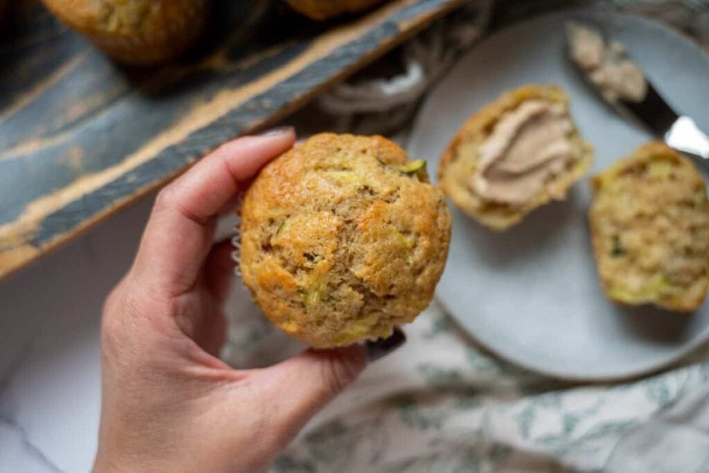 holding a sourdough zucchini muffin