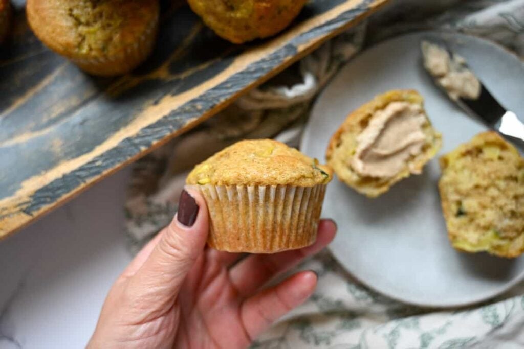 holding a sourdough zucchini muffin