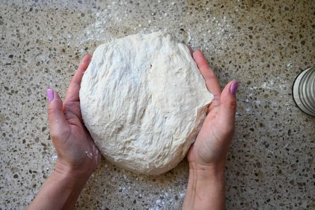 folding sourdough bread dough with two hands