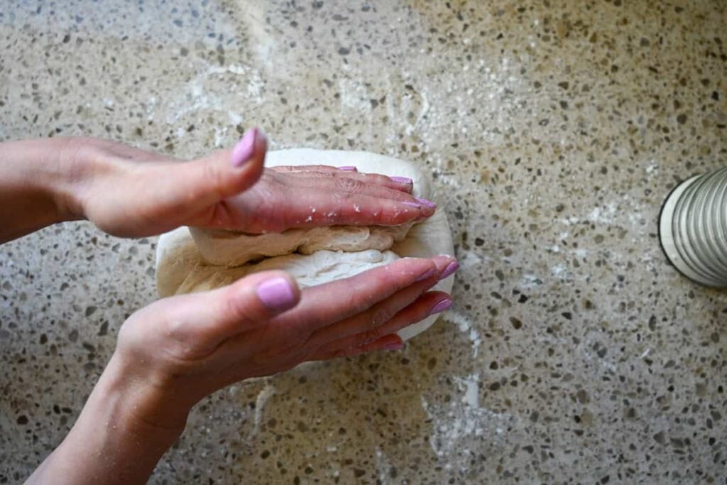folding sourdough bread dough with two hands