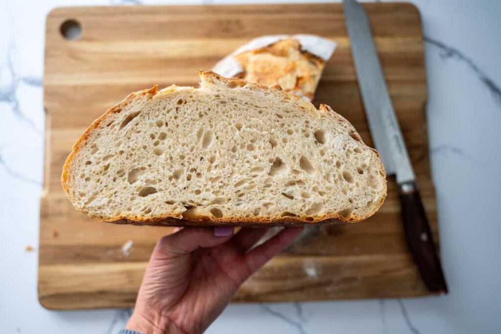 holding a half loaf of sourdough bread