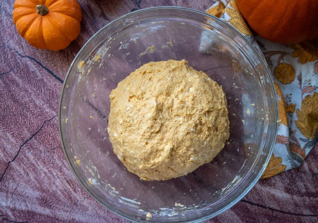 sourdough pumpkin cinnamon rolls dough in a glass bowl