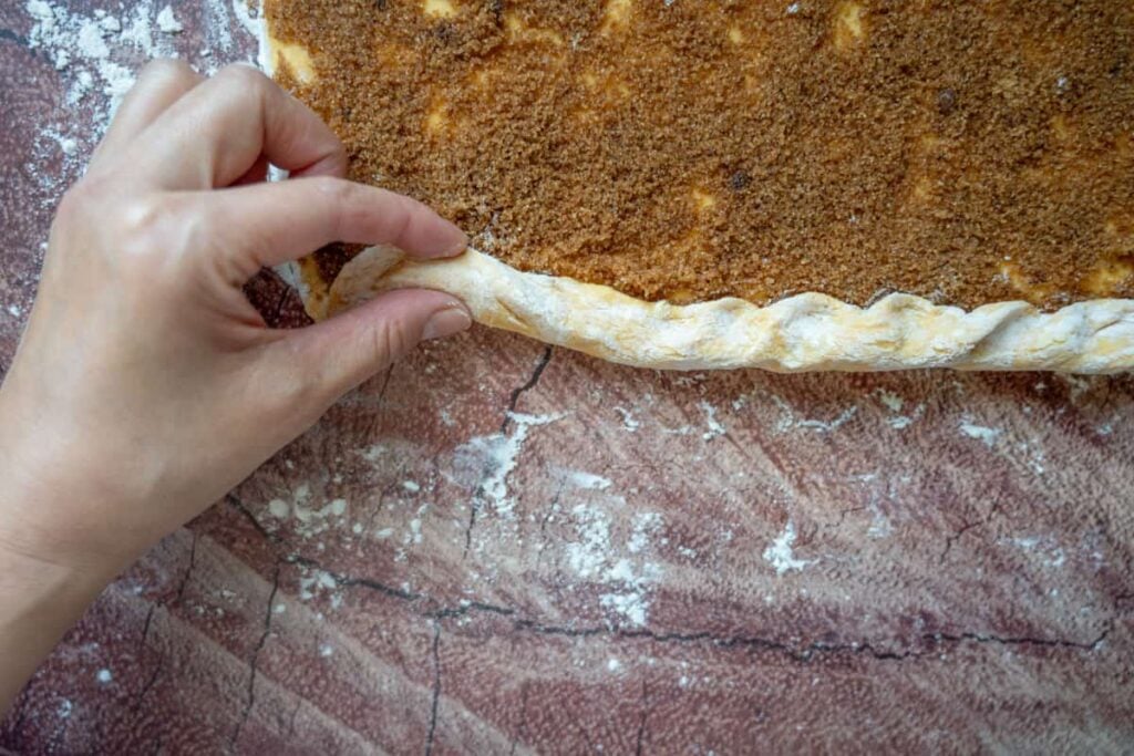 rolling up sourdough pumpkin cinnamon rolls dough