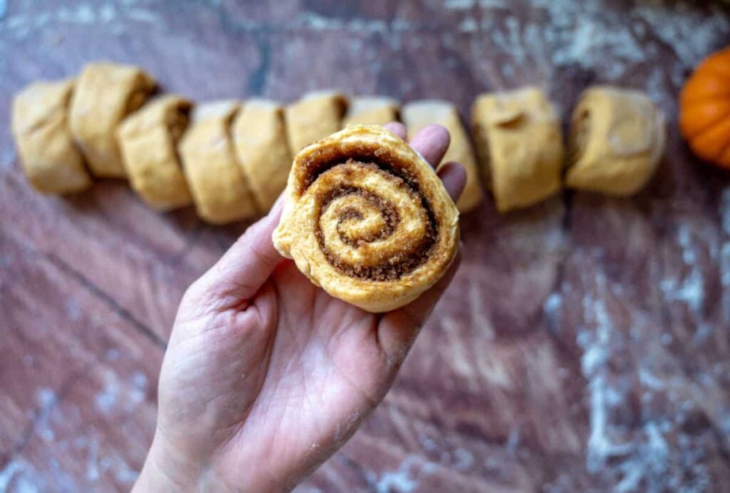 a cut sourdough pumpkin cinnamon rolls dough