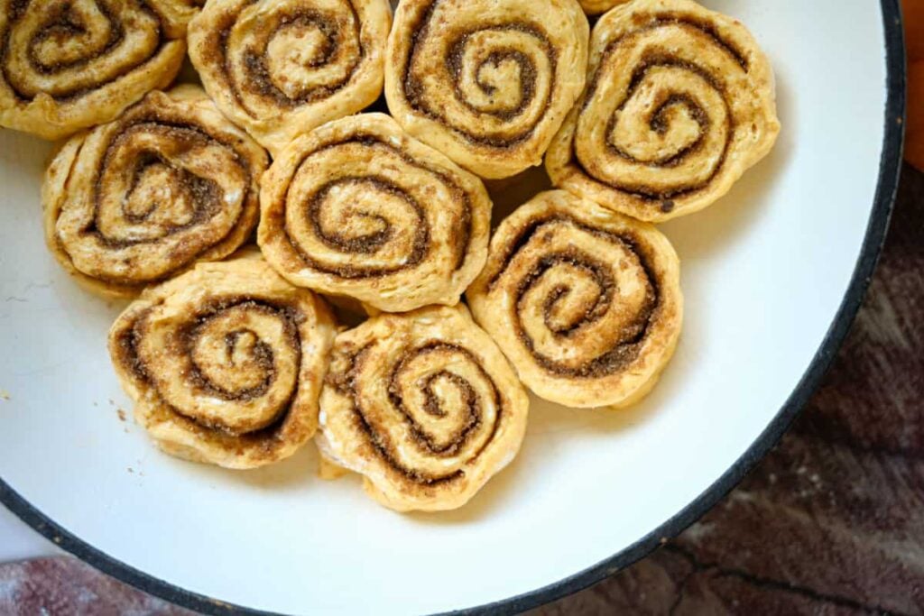 sourdough pumpkin cinnamon rolls in a braiser