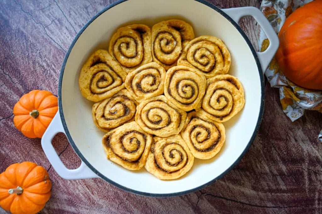proofed sourdough pumpkin cinnamon rolls in a braiser